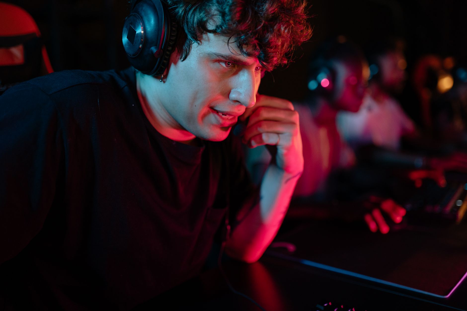 Jugador sonriendo con auriculares en cabina de juego oscura